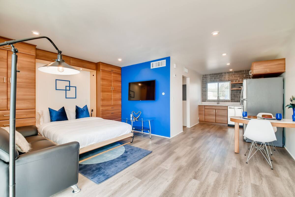 Une chambre moderne avec un grand lit, des tables de chevet et un bureau avec une chaise.