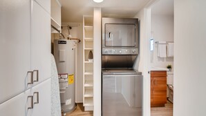 A compact kitchen with a built-in oven, a stainless steel refrigerator, and a water heater. - Hollywood Studios in Downtown Phoenix (Phoenix)