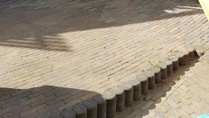 Un bâtiment doté d’un escalier en bois menant à un balcon, d’une porte rouge et d’un espace buanderie visible à travers une porte en verre.