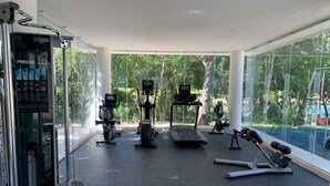 A modern gym with cardio machines, a rowing machine, and free weights. - LUXURY APARTMENT IN KAAN HA, BAHIA PRINCIPE (Akumal)