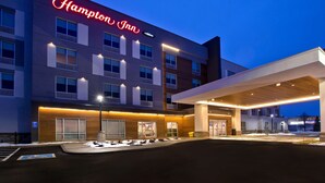 A Hampton Inn hotel with a modern facade, illuminated signage, and a covered parking area. - Hampton Inn by Hilton Brockville (Brockville)