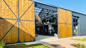 A modern building with large wooden panels and a glass entrance. - Bobo's Greenlee Lifestyle Studio Apartment (Sandton)