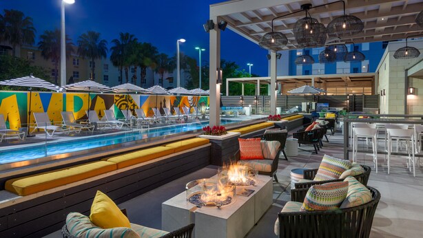A poolside area with lounge chairs, a fire pit, and outdoor seating. - Hyatt House Tampa Airport Westshore (Tampa)