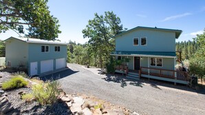 Une maison à deux étages avec un porche à l’avant et un garage.