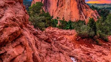 Un paisaje agreste con formaciones rocosas destacadas y un cielo al atardecer.