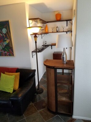 A living room with a black leather sofa, a small wooden table, and a floor lamp. - Silver Lake Hidden Jewel (Los Angeles)
