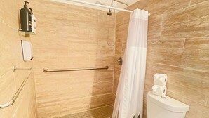A bathroom with a shower, toilet, and a small sink. - Casa Sevilla, Coqui Studio (San Juan)