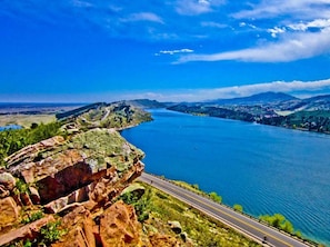 A coastal road with a clear view of the sea and distant hills.