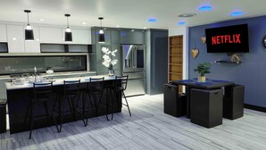 A modern kitchen with a central island, bar stools, and a built-in oven. - Villas Beach House(next to the main Blvd. walking distance to the beach & A/C) (Rosarito)