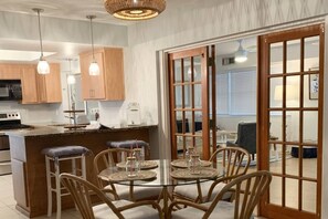 Una cucina moderna con mobili in legno, un'isola centrale e luci a sospensione.