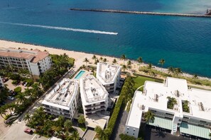 An aerial view of a coastal hotel with multiple buildings, a swimming pool, and a beach. - NEW Luxurious Condo/inlet & Ocean Views 106 Inlet Way Unit 103 - Palm Beach Shores (Singer Island)