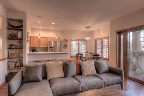 A modern kitchen with wooden cabinets, stainless steel appliances, and pendant lighting.