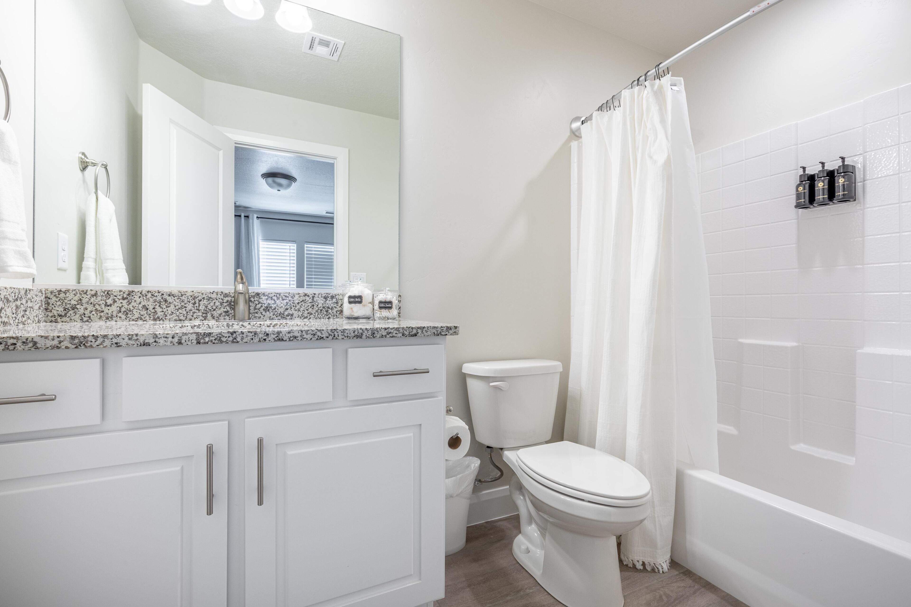 Une salle de bain avec des toilettes, un lavabo et un rideau de douche.