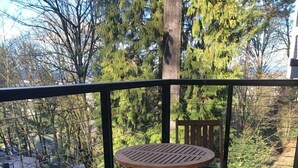 A wooden deck with a round table and two chairs, surrounded by a black railing. - Zen themed private retreat in NW Portland. (Portland)
