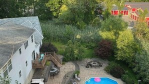 A residential property with a swimming pool, outdoor seating, and a garden. - Crew Road Cabana (Clifton Park)