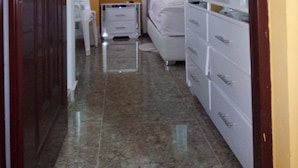 Un dormitorio con cama, cómoda, mesita de noche y equipo de aire acondicionado.