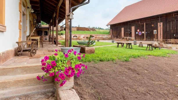 A rustic building with a red-tiled roof, wooden beams, and a covered outdoor seating area with tables and chairs. - Dolní Olešnice by Interhome (Hostinne)