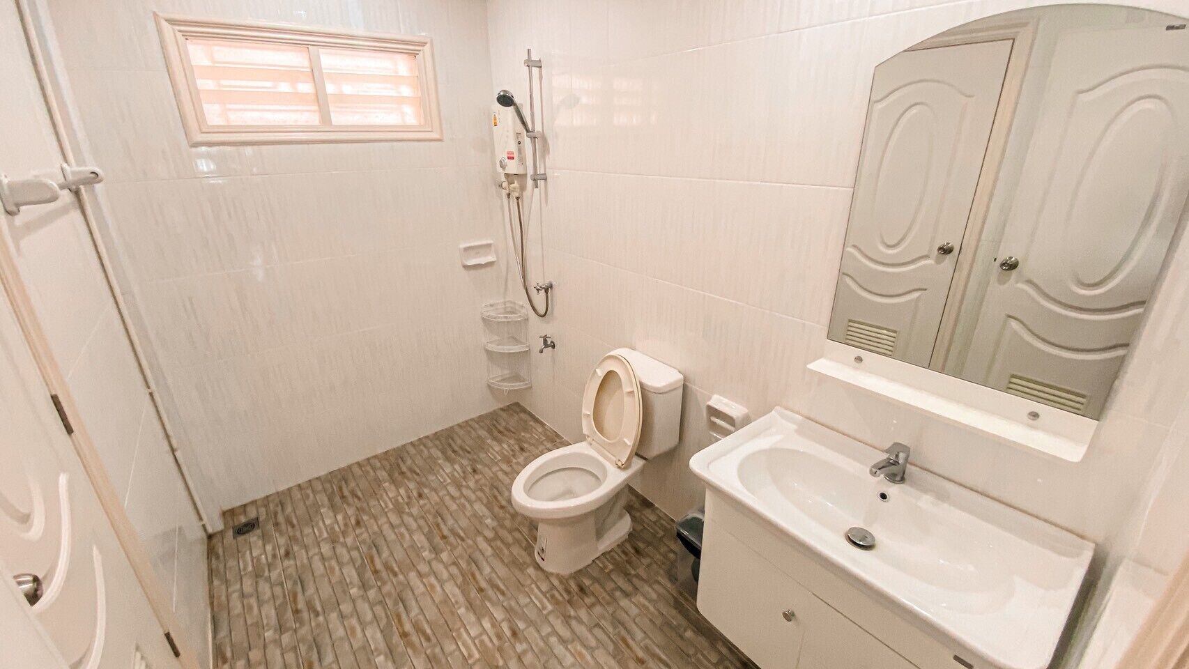 A bathroom with a toilet, sink, and shower.
