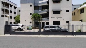 A multi-story building named Maria Eugenia I, featuring a modern architectural design with a flat roof and a gated entrance. - Residencial Las Dianas (Santiago de los Caballeros)