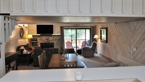 Una sala de estar acogedora con chimenea, un televisor de pantalla plana y un comedor con mesa y sillas.