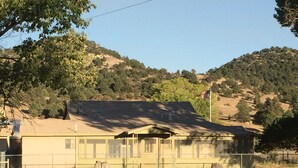 A single-story building with a flat roof, surrounded by a chain-link fence. - Hunters, Hikers, Campers Welcome! (Mule Creek)
