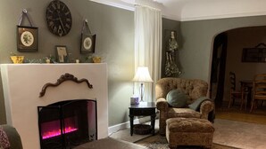 A cozy living room with a fireplace, patterned furniture, and a decorative rug. - Pleasant Street Suite in downtown Prescott (Prescott)