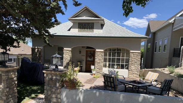 A house with a stone facade, a covered patio with outdoor furniture, and a large window. - Pleasant Street Suite in downtown Prescott (Prescott)