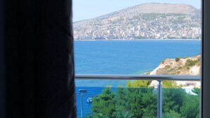 A coastal cityscape with a mountain in the background, viewed from a balcony with a railing. - Hotel Bella Vista (Sarandë)