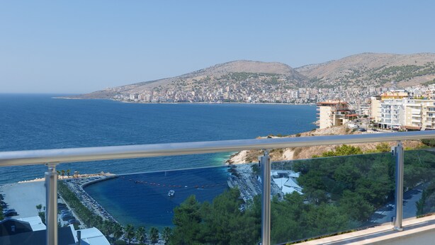 A coastal cityscape with a clear view of the sea, a beach, and a hilly background. - Hotel Bella Vista (Sarandë)