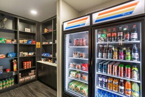 Un distributeur automatique rempli de diverses boissons et de collations, ainsi qu’un présentoir réfrigéré contenant des produits alimentaires emballés.