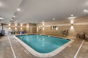 Une piscine intérieure avec des murs et un sol carrelés, ainsi qu’un panneau indiquant qu’il est interdit de plonger.