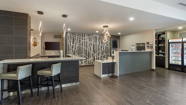 Une cuisine moderne dotée d’un coin bar, d’un réfrigérateur et d’un panneau mural décoratif.