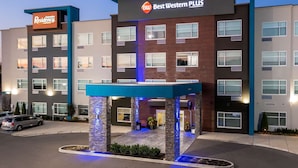 Un hôtel moderne, reconnaissable à son grand panneau « Best Western PLUS », doté d’une entrée abritée et d’un parking.