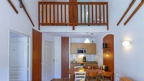 A compact living space with a kitchenette, a dining area, and a small seating area. - Pleasant duplex with parking - 7 guests (La Mongie)