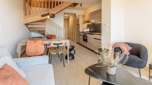 A modern apartment with a dining area, kitchen, and living room. - Cozy duplex with pool and spa, ski-in/ski-out (Les Arcs 1600)