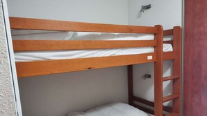 A bunk bed with a wooden frame and white bedding. - Charming studio - 4 guests - Near slopes (La Mongie)