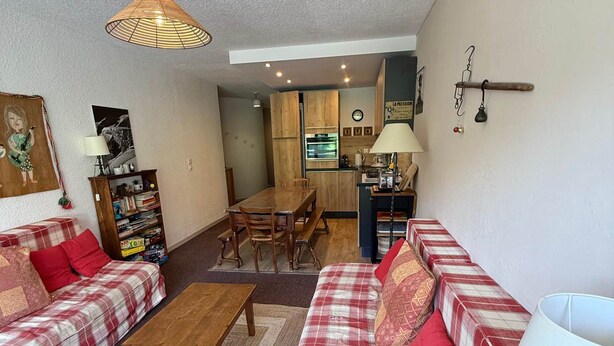 A living room with a sofa set, a wooden coffee table, and a dining area with a table and chairs. - 3-room apartment at the foot of the slopes, 7th floor (Les Adrets-Prapoutel)