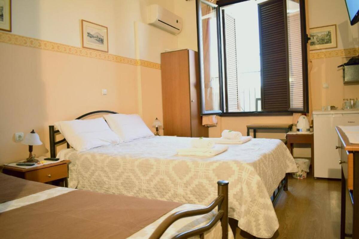 Une chambre d’hôtel équipée d’un lit, d’un bureau, d’une chaise, d’une armoire et d’une fenêtre avec des stores.