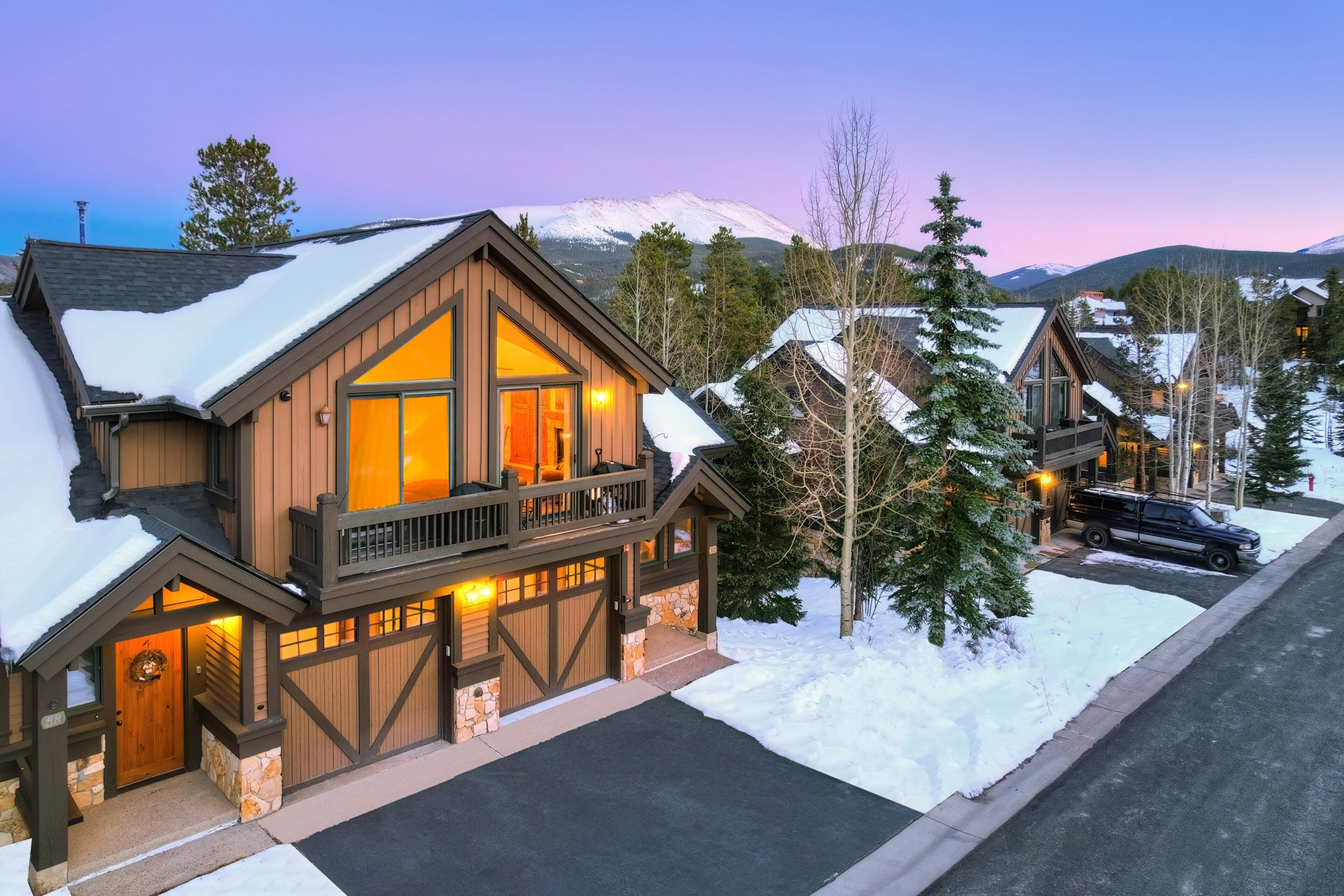 A two-story lodge with a wooden exterior, a balcony, and a garage.
