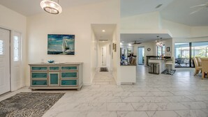 A spacious living area with a kitchen, dining area, and a hallway leading to bedrooms. - Wide Water Views, Hot Tub, Heated pool! 75 reviews.Villa 27 (Cape Coral)