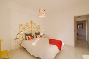 Ein Schlafzimmer mit einem Bett, einem Kopfteil, Nachttischen und einer Hängeleuchte.