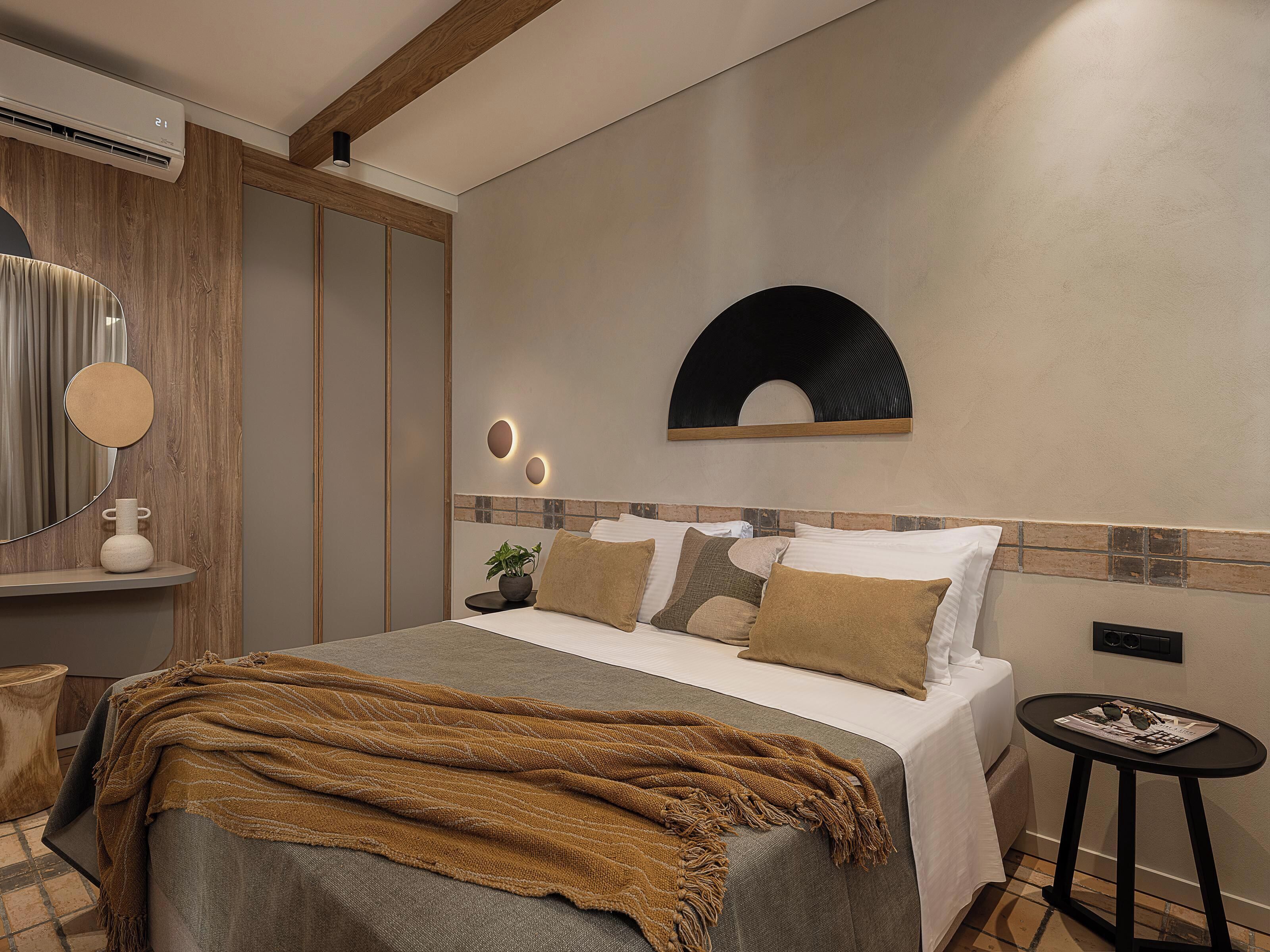 A modern bedroom with a bed, bedside table, and a mirror.