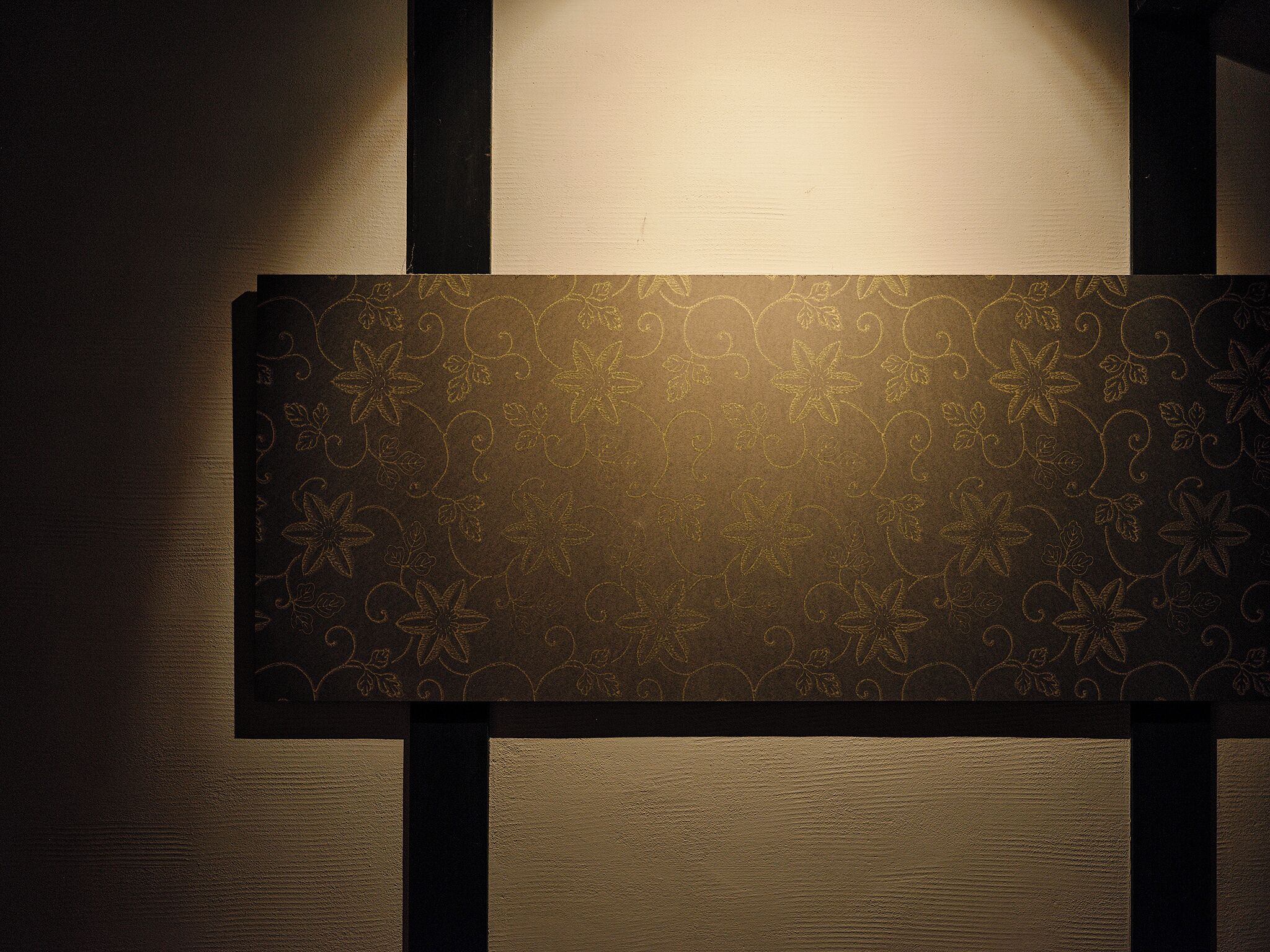 A wall with a decorative panel featuring a floral pattern.