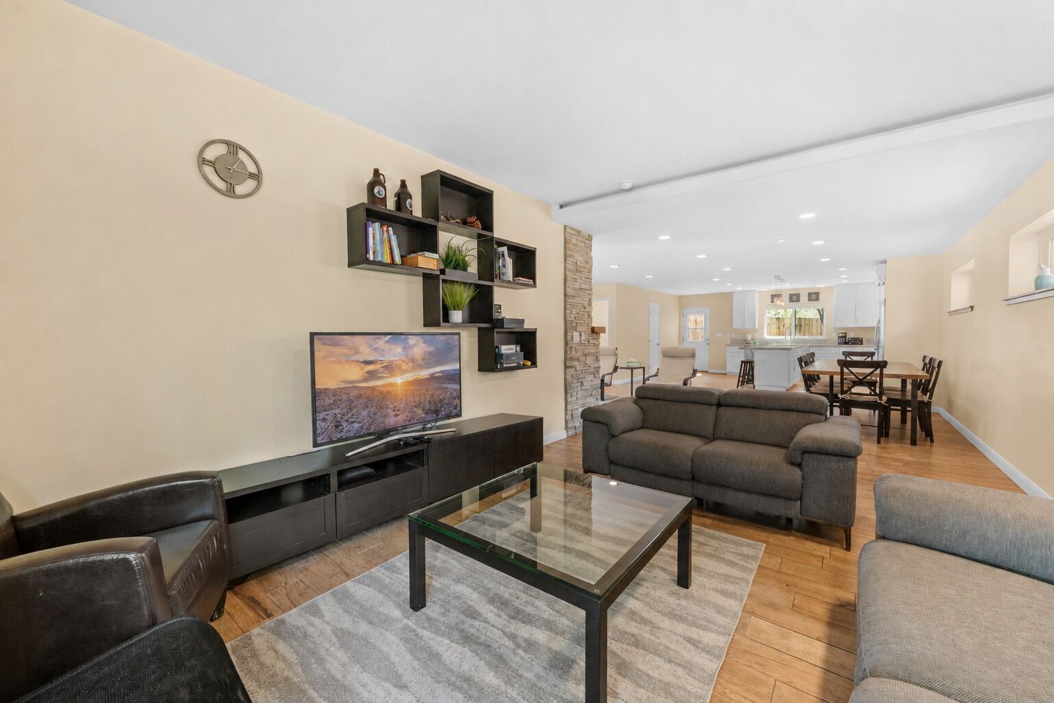 Una sala de estar moderna con un televisor de pantalla plana, un sofá modular y una mesa de centro de vidrio.