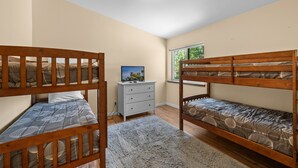 A bedroom with two bunk beds, a dresser, and a television. - Modern Times - Partial AC, Close to Lake & Village, Jet Tub, Fireplace, Barbecue (Big Bear Lake)