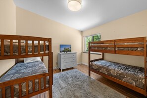 A bedroom with two bunk beds, a dresser, and a television. - Modern Times - Partial AC, Close to Lake & Village, Jet Tub, Fireplace, Barbecue (Big Bear Lake)
