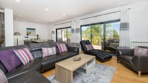 Ein modernes Wohnzimmer mit einem schwarzen Ledersofa, einem Holztisch und einem Glastisch.