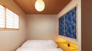 Ein Schlafzimmer mit einem Bett, einem Wandregal und einem blauen Dekor an der Wand.