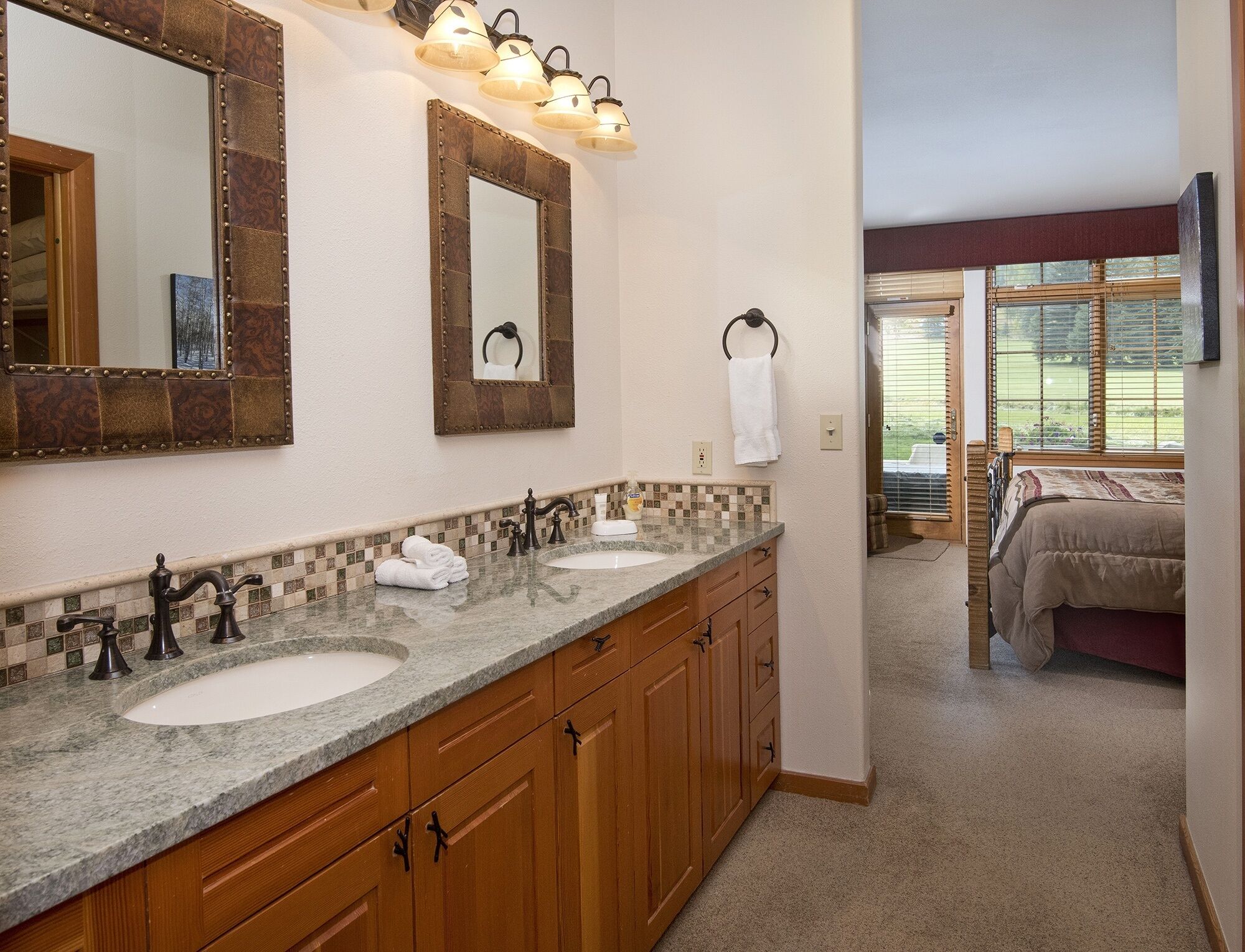Une salle de bain avec deux lavabos, des meubles en bois et un grand miroir.