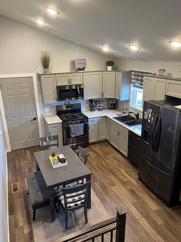 A modern kitchen with a central island, stainless steel appliances, and a dining area with a table and chairs.